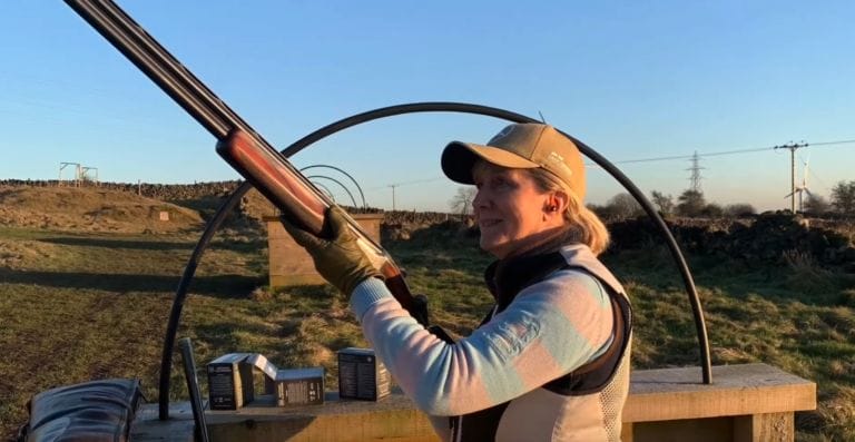 Woman shooting a shotgun